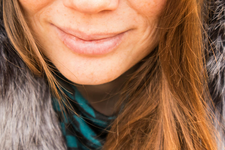 woman lips moisturize using natural lip balm/moisturizer